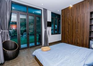 a bedroom with a bed and a large window at Story Villa Tam Đảo - Venuestay in Vĩnh Phúc