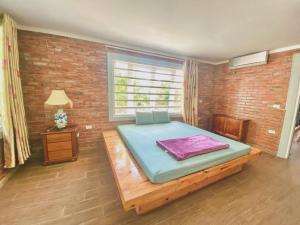 ein Schlafzimmer mit einem Bett und einer Ziegelwand in der Unterkunft Brick Home Villa Sóc Sơn - Venue Travel in Hanoi + 29 Fotos