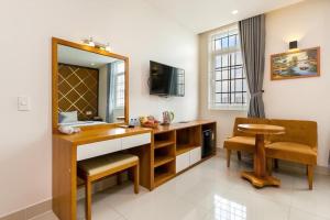 a bathroom with a vanity with a mirror and a chair at khách sạn Thiên Cung in Ho Chi Minh City