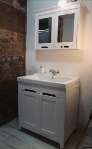 a bathroom with a white sink and a mirror at Breathe Nature - Beach House Azores in Feteira