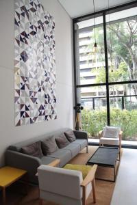 sala de estar con sofá y ventana grande en 68 Brand-new studio next to Paulista Av, fast wifi, en São Paulo