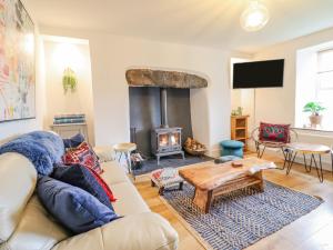 a living room with a couch and a fire place at Cefn Nannau in Corwen