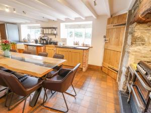 a large kitchen with a wooden table and chairs at Cefn Nannau in Corwen