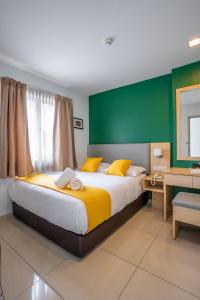 sypialnia z dużym łóżkiem i zieloną ścianą w obiekcie V Hotel Pudu Kuala Lumpur w Kuala Lumpur