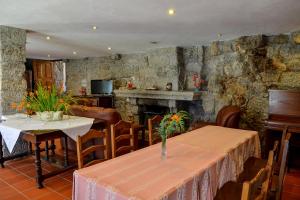 a dining room with two tables and a fireplace at Quinta Brasão Da Caniçada in Caniçada