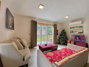 a living room with a couch and a christmas tree at Biệt Thự Con Công Sóc Sơn Venuestay in Phú Hữu +72 photos