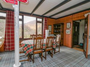 a dining room with a table and some windows at Coire-Dhiubh in Glenfinnan