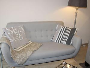- un canapé avec des oreillers dans le salon dans l'établissement Nice apartment with terrace near the sea, à Bray-Dunes