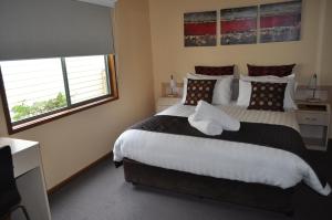 a bedroom with a bed and a window at Kangerong Holiday Park in Dromana