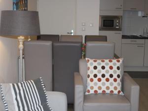 a living room with a chair and a pillow and a lamp at Nice apartment with terrace near the sea in Bray-Dunes