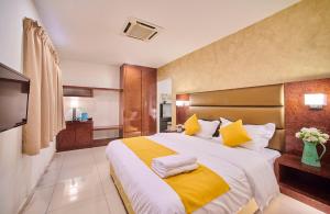 a bedroom with a large bed with yellow and white pillows at V Hotel Pudu Kuala Lumpur in Kuala Lumpur