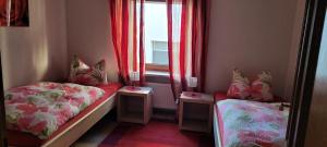 Habitación pequeña con 2 camas y ventana en Bergsteiger, en Sandberg