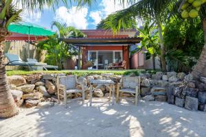 a table and chairs in front of a stone wall at Gecko Beach Villas in Hinkong