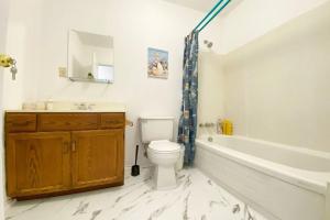 a bathroom with a tub and a toilet and a sink at Tobermory Cozy Lighthouse Cottage -locate 3min from downtown in Tobermory