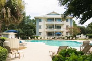 a large building with a swimming pool and chairs at Fiddlers Cove III in Hilton Head Island