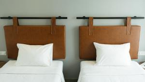 two beds with white pillows in a room at Em Oi Boutique Hotel in Nha Trang
