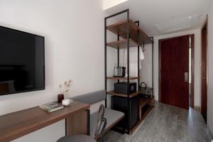 a living room with a flat screen tv and a table at Em Oi Boutique Hotel in Nha Trang