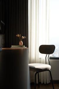 a chair sitting next to a table with a window at Em Oi Boutique Hotel in Nha Trang