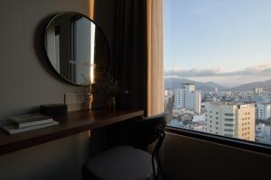 a mirror in a room with a view of a city at Em Oi Boutique Hotel in Nha Trang