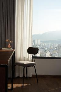 a chair sitting in front of a window with a view at Em Oi Boutique Hotel in Nha Trang
