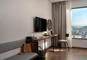 a hotel room with a desk and a large window at Em Oi Boutique Hotel in Nha Trang
