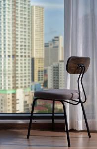 a chair sitting in front of a window at Em Oi Boutique Hotel in Nha Trang