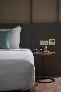 a bedroom with a bed and a table with a clock on it at Em Oi Boutique Hotel in Nha Trang