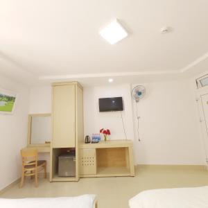 a bedroom with a desk and a tv on the wall at Daisy Dalat House in Da Lat