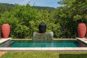 uma estátua de um busto sentado ao lado de uma piscina em The Zarafa em Hazyview