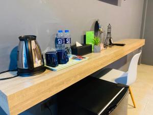 a wooden counter with a kettle and water bottles on it at S1 City Hotel Buriram in Buriram