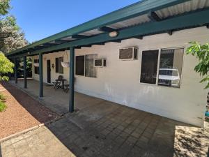 a white house with a green roof and a patio at The Cottage on George Street in Jarrahdale