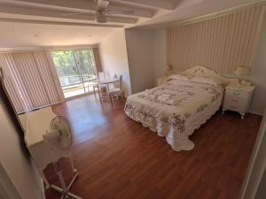 a bedroom with a bed and a table with a fan at The Cottage on George Street in Jarrahdale