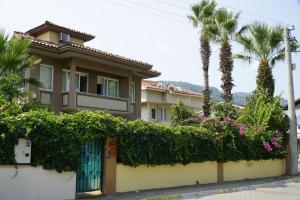 ein Haus mit einem Zaun und Palmen in der Unterkunft Mountain View Villa Marmaris in Marmaris