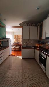 a kitchen with white cabinets and a tile floor at Villa Elena in Manerba del Garda