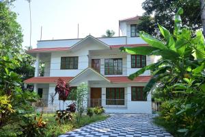 a house with a pathway in front of it at Devi Kripa Residency in Varkala