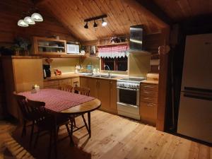 cocina con mesa y cocina con suelo de madera en Nås Camping Dalarna, stuga nr 6, en Nås