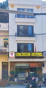 een gebouw met een hotelbord ervoor bij Orchids Hotel in Sa Pa