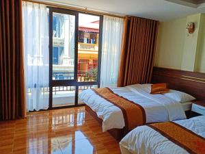 een hotelkamer met 2 bedden en een balkon bij Orchids Hotel in Sa Pa