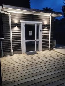 ein Haus mit einer Tür auf einem Deck in der Nacht in der Unterkunft Sleepout Hideaway in Rotorua