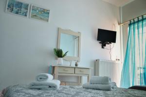 a bedroom with a bed and a mirror and a tv at Dinos Studios in Paralía Kanalíou