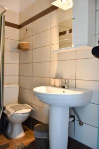 a bathroom with a sink and a toilet at Dinos Studios in Paralía Kanalíou +19 photos