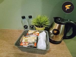 una cesta en una mesa con una cafetera y bebidas en The S Design Hotel, en Buriram