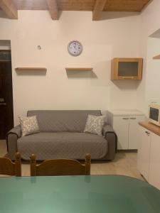 ein Wohnzimmer mit einem Sofa und einer Uhr an der Wand in der Unterkunft Casa Dodò al mare di Soverato in Soverato Marina