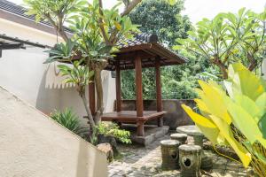a gazebo in the middle of a garden at Gumitish Guest House Singaraja in Singaraja