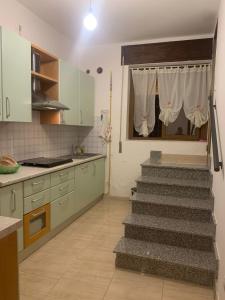 a kitchen with a staircase in the middle of a kitchen at Casa Dodò al mare di Soverato in Soverato Marina