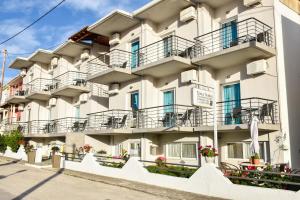 an apartment building with balconies on a street at Dinos Studios in Paralía Kanalíou