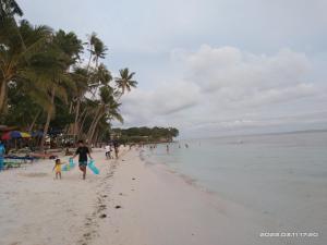 a group of people walking on the beach at Villa Almedilla Pension House in Panglao Island