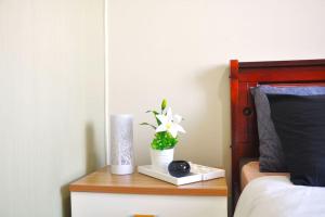 einen Tisch mit einer Blumenvase auf dem Bett in der Unterkunft BREATHTAKING TAAL VIEW! TAGAYTAY WIND RESIDENCES MODERN SUITE 23F in Tagaytay
