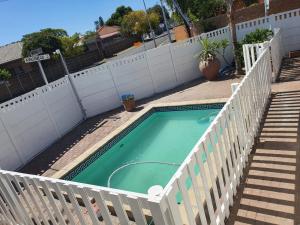 una pequeña piscina con una valla blanca en The White House Lodge, en Ciudad del Cabo