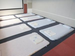 Una cama o camas en una habitación de Natural Onsen Hostel Hidamari no Yu